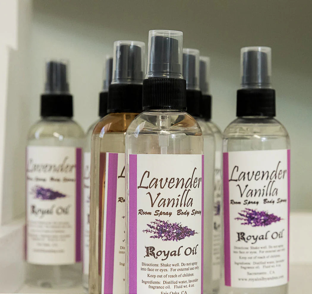 Gemini said Multiple clear spray bottles of Royal Oil Lavender Vanilla Room and Body Spray arranged in a group. The white labels feature purple accents and a lavender sprig graphic. The bottles have black spray nozzles and clear plastic caps.