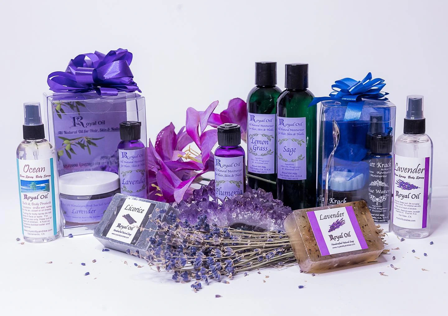 Collection of lavender-themed products including bottles, sprays, and a bar of soap on a white background.