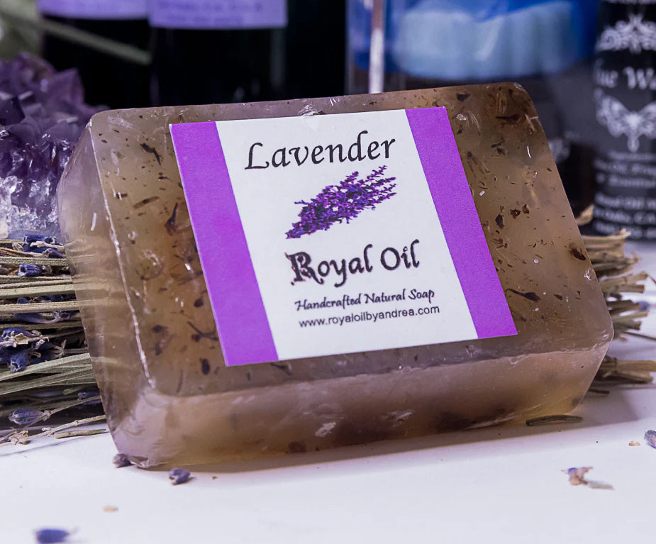 Bar of lavender soap with a label on a surface with lavender flowers and crystals.